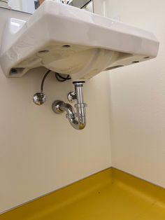 a white sink mounted to the side of a wall