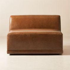 a brown leather couch sitting on top of a white floor