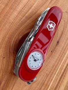 a red case with a clock inside on a wooden table