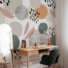 a desk and chair in front of a wall with an abstract design on it, next to a mirror