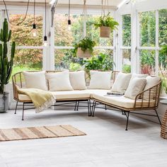 a living room filled with lots of furniture and plants