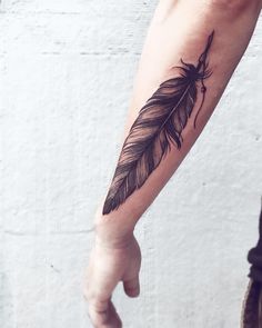 a person with a feather tattoo on their arm