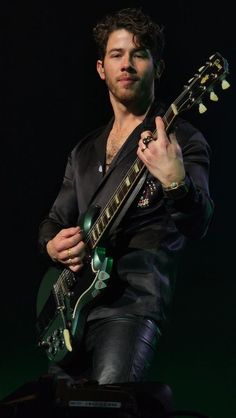 a man playing an electric guitar on stage