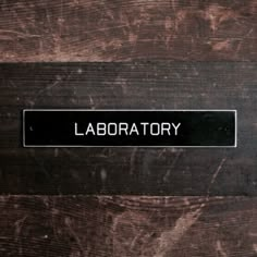 a sign that is on the side of a wooden door saying labratory,