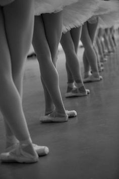 several ballerinas are lined up in their tutu skirts