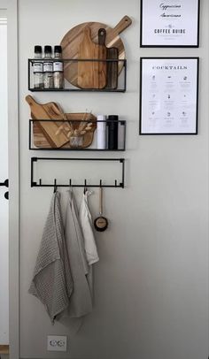 two wooden cutting boards mounted to the side of a wall next to kitchen utensils