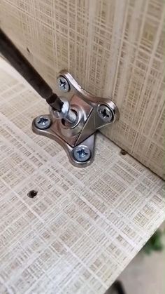 a close up of a metal handle on a wooden door with holes in the wood