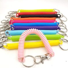 several different colored keychains with metal hooks on each side and one has a loop in the middle