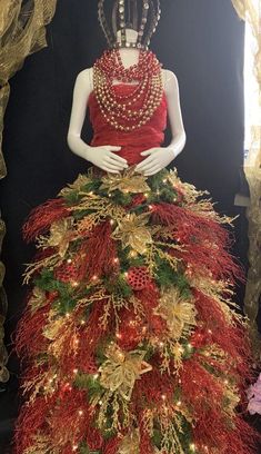 a mannequin wearing a red dress with gold and green decorations on it's skirt