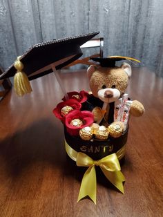 a teddy bear sitting in a graduation hat with chocolates, candy and candies