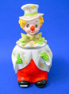 a clown figurine sitting on top of a blue surface