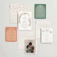 an assortment of wedding stationery items displayed on a white surface, including cards and envelopes