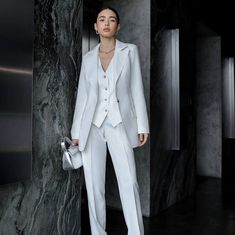 Elevate your bridal style with our exquisite women's 3-piece suit, a blend of elegance, sophistication, and modern flair. Tailored to perfection, this ensemble is designed to make you feel confident and radiant on your special day. Crafted with meticulous attention to detail, our white pantsuit exudes timeless charm and grace. Whether you're walking down the aisle or celebrating at your reception, this suit is a symbol of your unique style and individuality. Each piece of this ensemble, from the White Tailored Pants For Semi-formal Occasions, Luxury Notch Lapel Wedding Pantsuit, Luxury Notch Lapel Pantsuit For Wedding, Tailored Classic Wedding Pants, Classic Tailored Pants For Wedding, Tailored Classic Pants For Wedding, Elegant Office Pantsuit, Elegant Tailored Blazer For Wedding, Elegant Notch Lapel Suit For Wedding