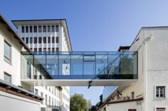 a glass walkway between two buildings in the city