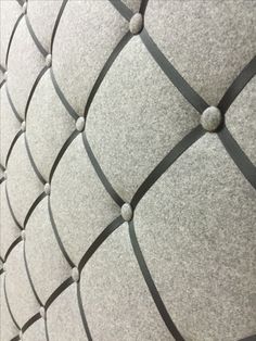 an upholstered wall with black and white lines on the bottom, and round buttons at the top