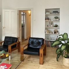 a living room filled with furniture and a glass top coffee table in front of a fireplace