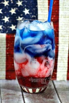 an american flag drink in a glass with a straw sticking out of the top, on a wooden table