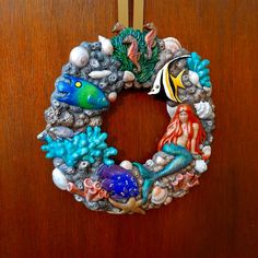 a wreath made out of seashells and other sea creatures on a door handle