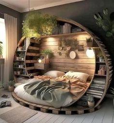 a round bed in the middle of a room with bookshelves and plants on it