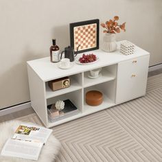 a white entertainment center with shelves, vases and other items on top of it