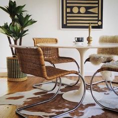 two chairs sitting at a table with a cow hide rug on the floor next to it