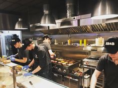 four men working in a restaurant kitchen preparing food