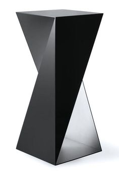 a black vase sitting on top of a white table