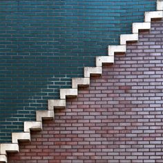 a brick wall with white steps going up it's side to the top and bottom