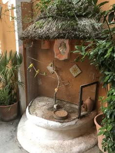 an outdoor fountain with plants and potted plants on the outside wall in front of it