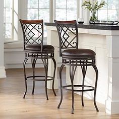 two brown barstools sitting next to each other on top of a wooden floor