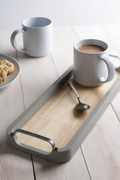 there is a tray with a cup of coffee on it and two cookies next to it