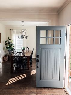 an open door leading to a dining room with chairs and a table in front of it