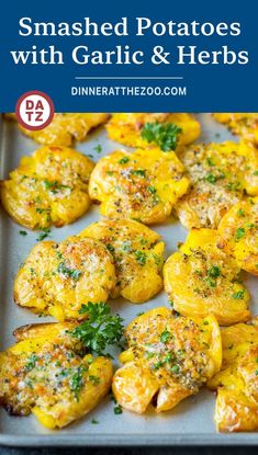 roasted potatoes with garlic and herbs on a baking sheet in a pan text overlay reads smashed potatoes with garlic and herbs