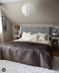 a bedroom with a bed, nightstands and pictures hanging on the wall above it