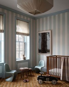 a baby's room with striped walls and furniture