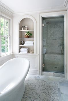 a white bath tub sitting next to a walk in shower