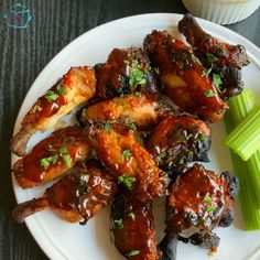 chicken wings and celery on a white plate