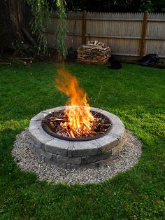 a fire pit sitting on top of a lush green field