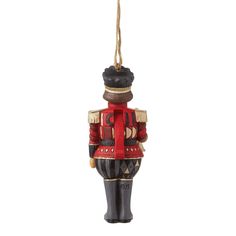 a nutcracker ornament hanging from a rope on a white background,