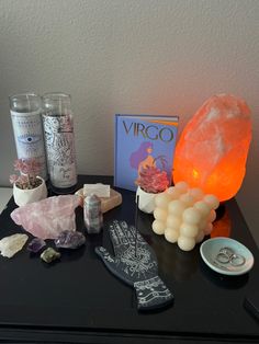 a table topped with lots of different types of rocks and crystals next to a book