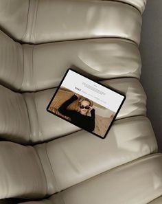 a laptop computer sitting on top of a leather couch