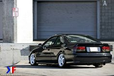 a black car parked in front of a garage