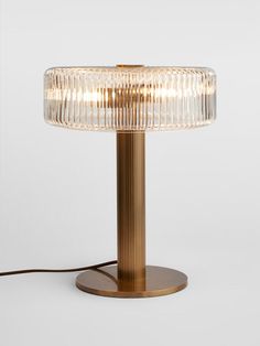 a table lamp that is on top of a wooden base and has a glass shade