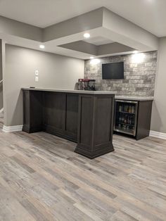 a basement bar with built in wine coolers and an entertainment center on the far wall