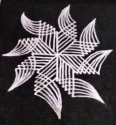 a snowflake made out of white thread on a black tablecloth with an intricate design