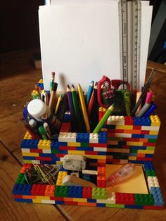 a lego pen holder with pens, pencils and markers