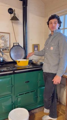 a man standing in front of a stove with a yellow bowl on top of it