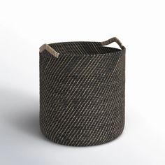 a large woven basket with handles on an isolated white background for use as a storage container