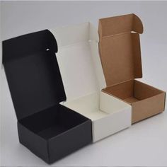 two open boxes sitting next to each other on a white surface with one opened and the other closed