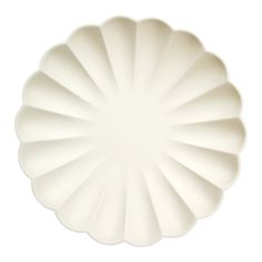 a large white plate with scalloped edges on a white background, viewed from above